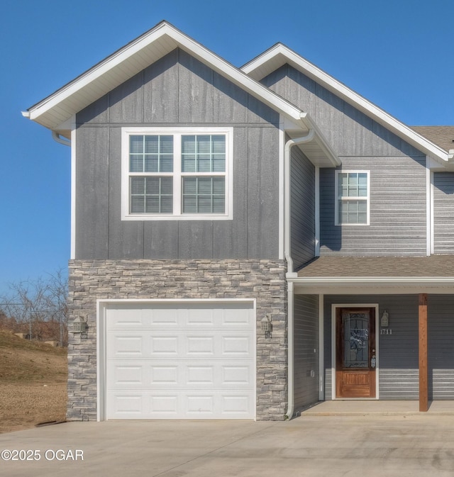 craftsman-style house featuring stone siding, concrete driveway, an attached garage, and a shingled roof