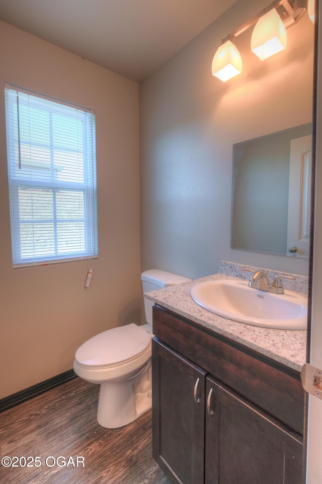 bathroom featuring wood finished floors, vanity, toilet, and baseboards