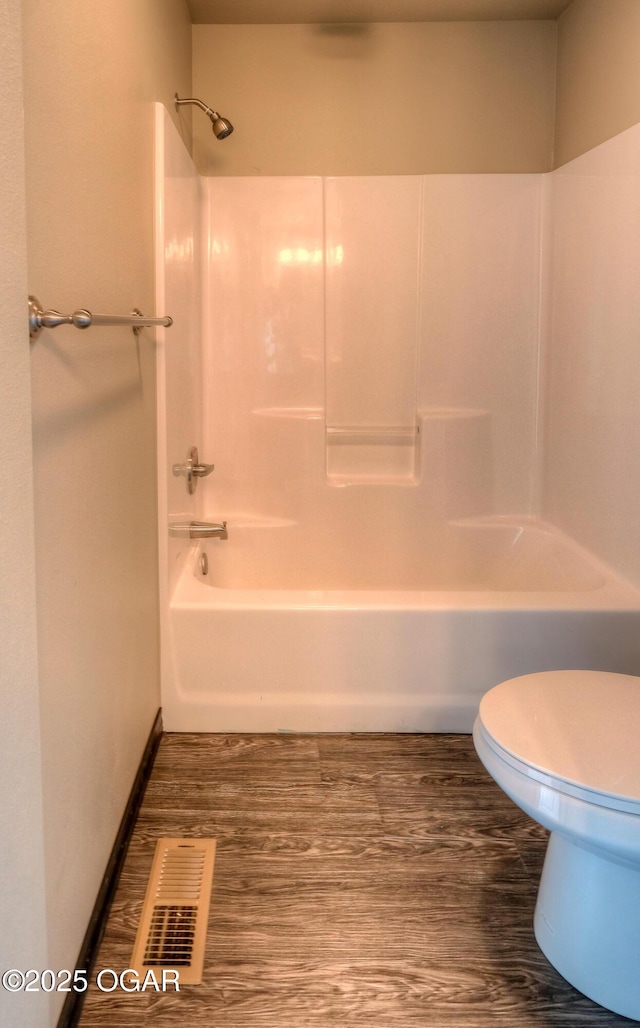 full bathroom with toilet, bathtub / shower combination, and wood finished floors
