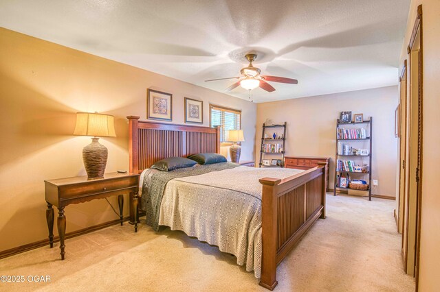 bedroom with light colored carpet, baseboards, and ceiling fan
