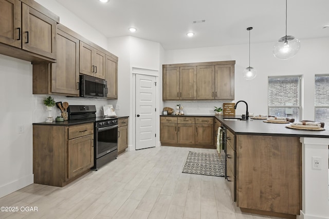 1318 Foundry Dr, Carthage, MO 64836 - kitchen featuring gas range oven, a sink, a peninsula, dark countertops, and recessed lighting