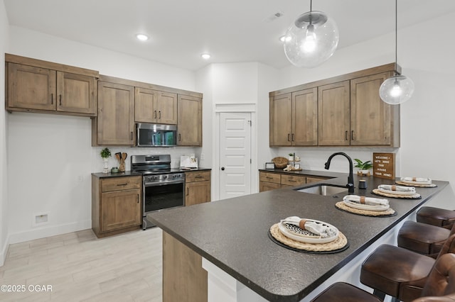 1318 Foundry Dr, Carthage, MO 64836 - kitchen with stainless steel appliances, dark countertops, a sink, a breakfast bar area, and a peninsula