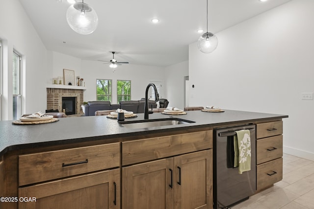 1318 Foundry Dr, Carthage, MO 64836 - kitchen featuring a sink, stainless steel dishwasher, dark countertops, a ceiling fan, and a fireplace