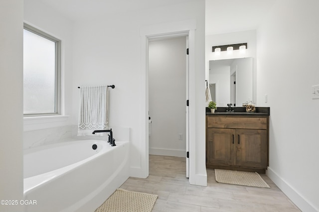 1318 Foundry Dr, Carthage, MO 64836 - bathroom featuring a bath, vanity, baseboards, and wood finished floors
