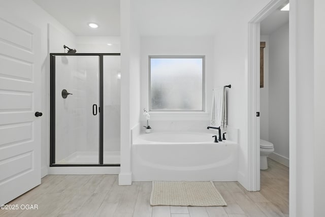 1318 Foundry Dr, Carthage, MO 64836 - full bath featuring a stall shower, a garden tub, toilet, and wood finished floors