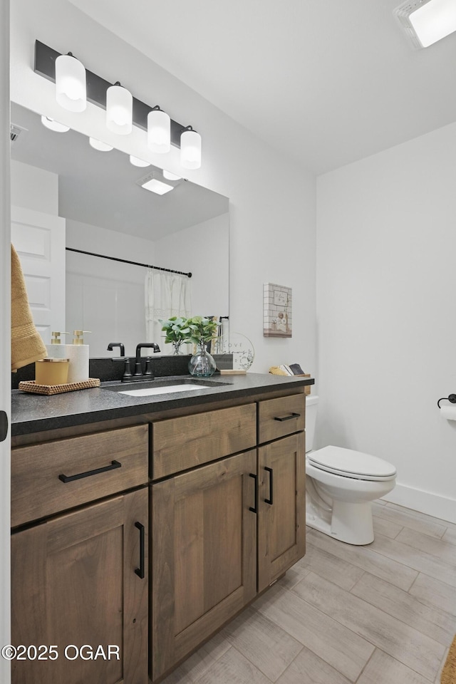 1318 Foundry Dr, Carthage, MO 64836 - full bath featuring toilet, vanity, wood finished floors, and baseboards