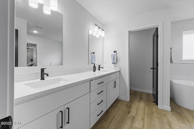 1528 N Edgemont Cir, Springfield, MO 65802 - ensuite bathroom with wood finished floors, double vanity, a freestanding bath, and baseboards