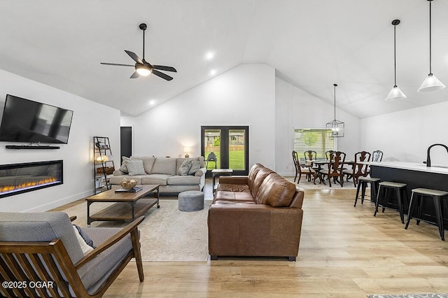 1528 N Edgemont Cir, Springfield, MO 65802 - living area featuring high vaulted ceiling, light wood-type flooring, a glass covered fireplace, and ceiling fan