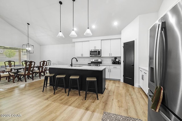 1528 N Edgemont Cir, Springfield, MO 65802 - kitchen with appliances with stainless steel finishes, a sink, a kitchen bar, light countertops, and light wood-type flooring