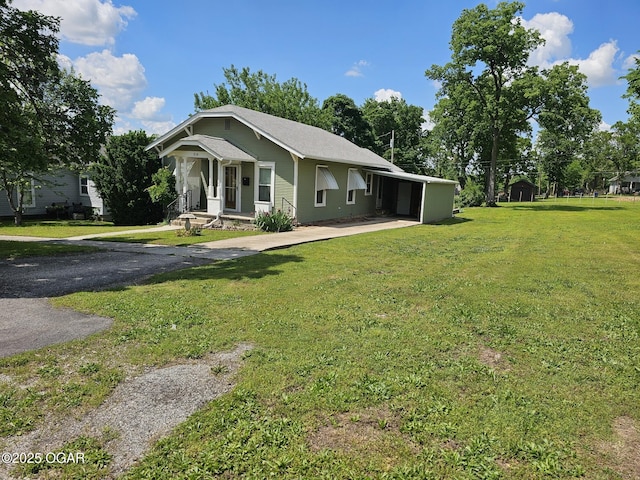 view of front of property featuring a front lawn, an attached carport, and driveway