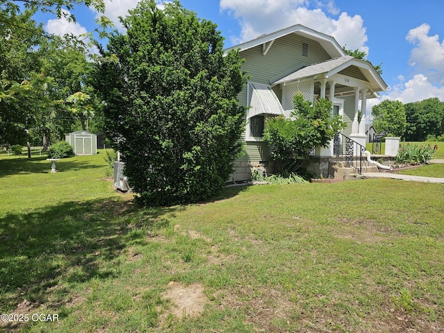 view of side of home with a shed, a yard, and an outdoor structure