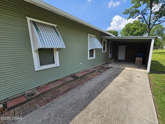 view of side of property featuring driveway and an attached carport