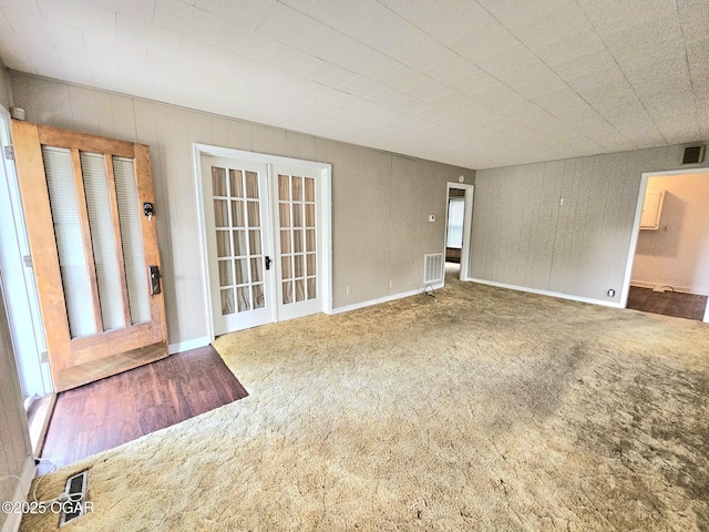 carpeted empty room with french doors and baseboards