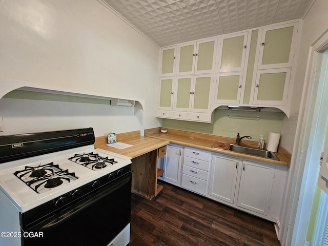 kitchen with gas range oven, a sink, dark wood-style floors, light countertops, and glass insert cabinets