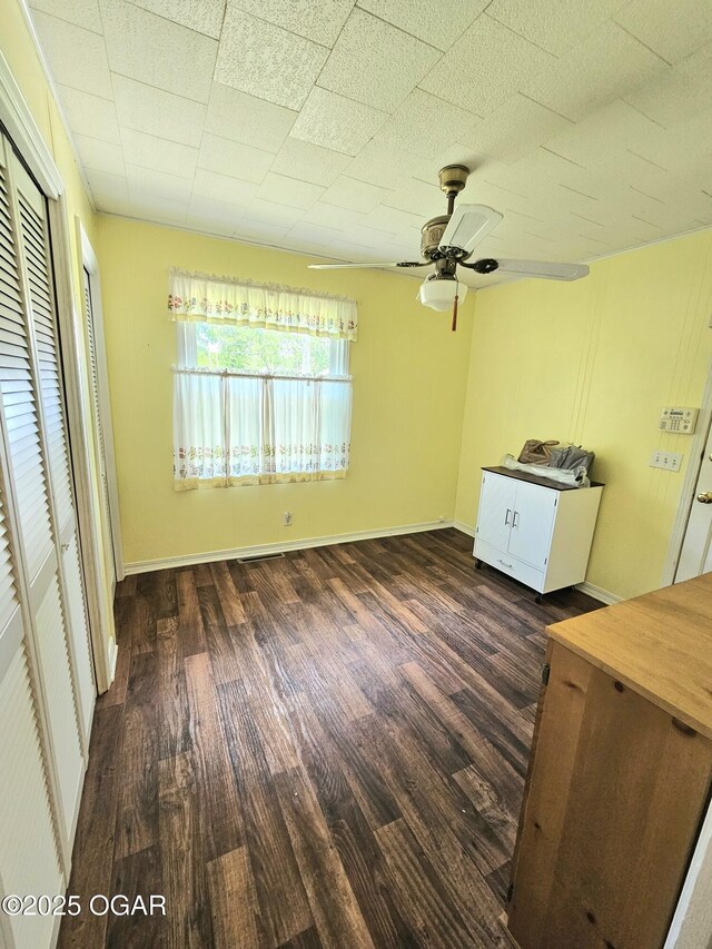 unfurnished bedroom with wood finished floors, a ceiling fan, and baseboards