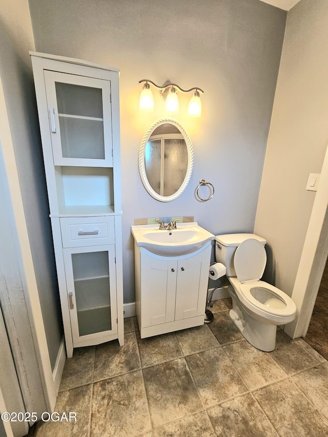 bathroom featuring baseboards, toilet, and vanity