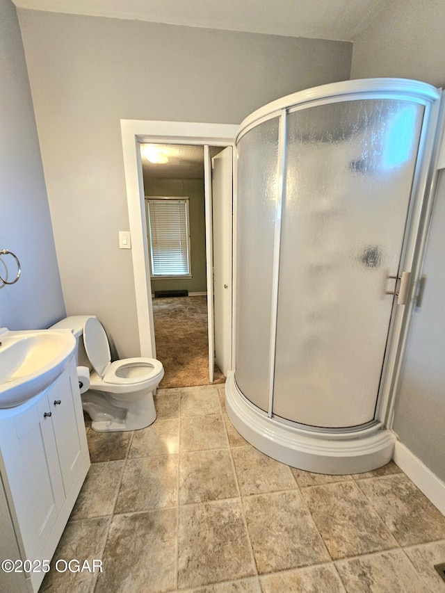 full bath with a stall shower, vanity, toilet, and baseboards