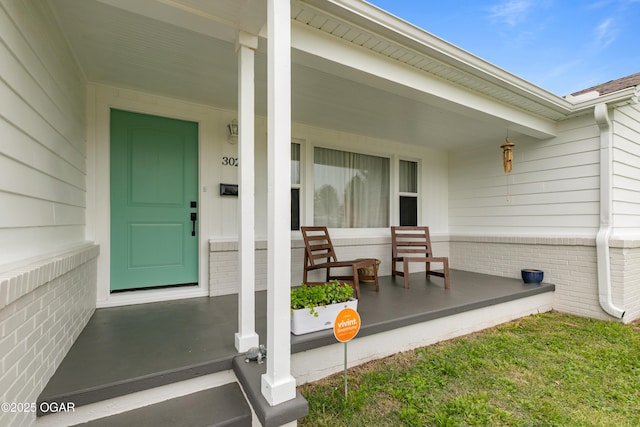 view of exterior entry featuring covered porch