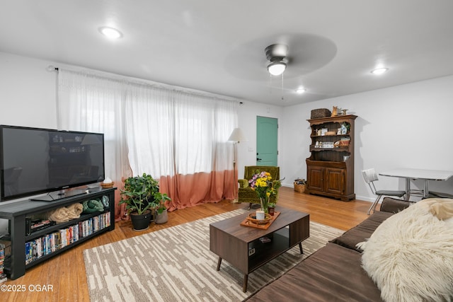 living area featuring ceiling fan, wood finished floors, and baseboards