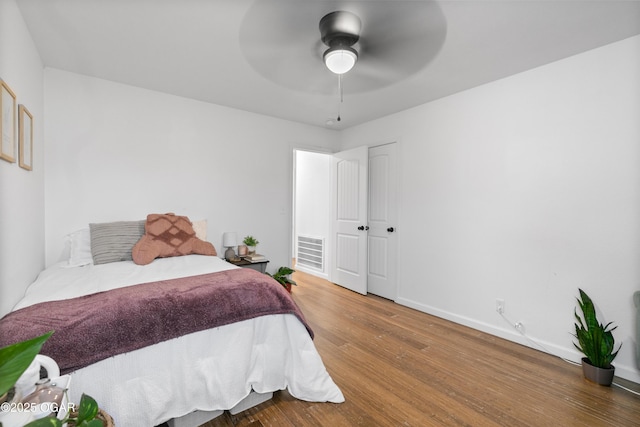 bedroom featuring wood finished floors, baseboards, and a ceiling fan