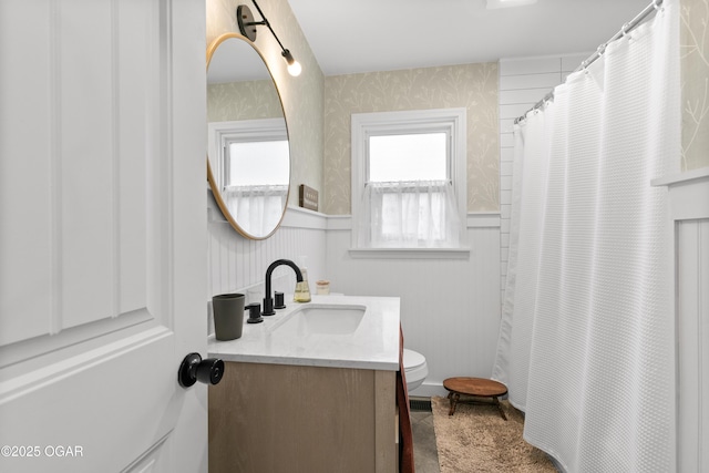 full bathroom with wallpapered walls, wainscoting, vanity, toilet, and a shower with curtain
