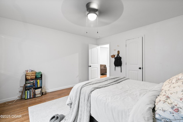 bedroom featuring wood finished floors, baseboards, and ceiling fan
