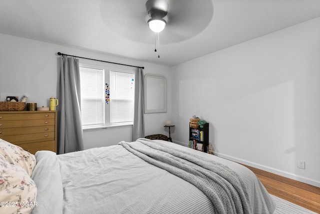 bedroom with wood finished floors, baseboards, and a ceiling fan