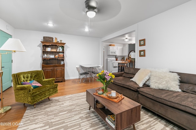 living area featuring light wood-type flooring and ceiling fan