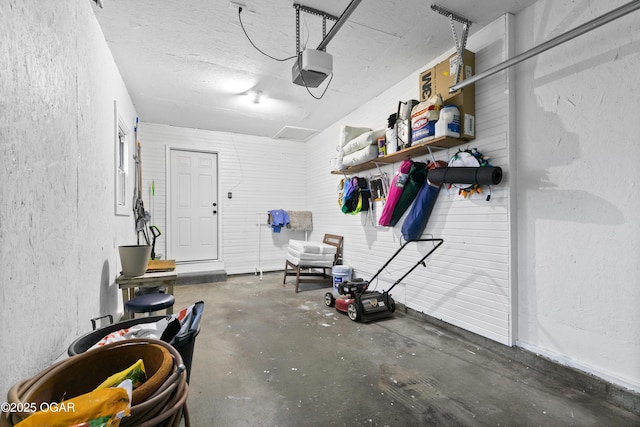 garage featuring a garage door opener and a textured wall
