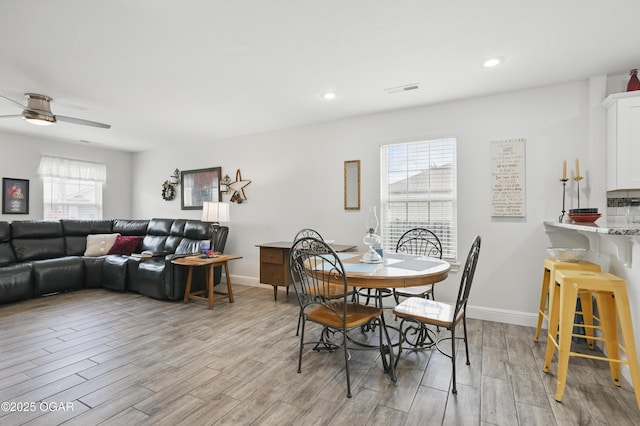 dining room with light wood-type flooring, a ceiling fan, baseboards, and recessed lighting