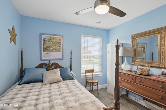 bedroom with wood finished floors, baseboards, and a ceiling fan