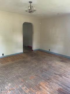 426 N Jackson Ave, Joplin, MO 64801 - empty room with arched walkways, baseboards, and a chandelier