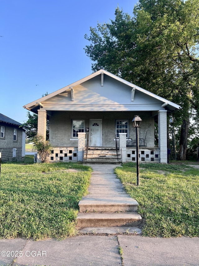 210 W 4th St, Webb City, MO 64870 - bungalow featuring a porch and a front lawn