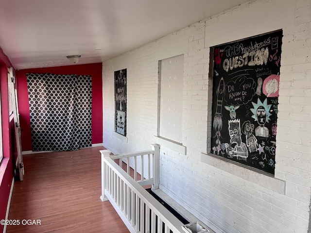 210 W 4th St, Webb City, MO 64870 - corridor with brick wall, an upstairs landing, and wood finished floors