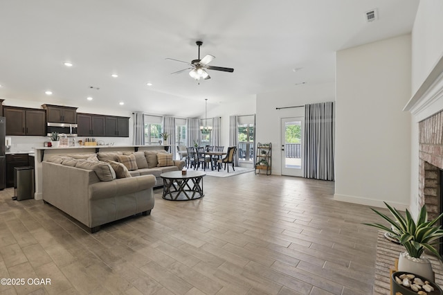 1020 S Florida Ave, Joplin, MO 64801 - living room with plenty of natural light, a ceiling fan, recessed lighting, light wood-type flooring, and a brick fireplace