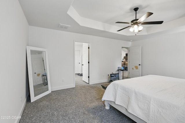 1020 S Florida Ave, Joplin, MO 64801 - carpeted bedroom with a tray ceiling, baseboards, a ceiling fan, and connected bathroom