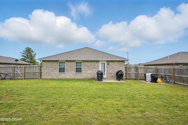 2102 Birdie Ln, Neosho, MO 64850 - rear view of house featuring a fenced backyard, brick siding, a patio area, and a shingled roof