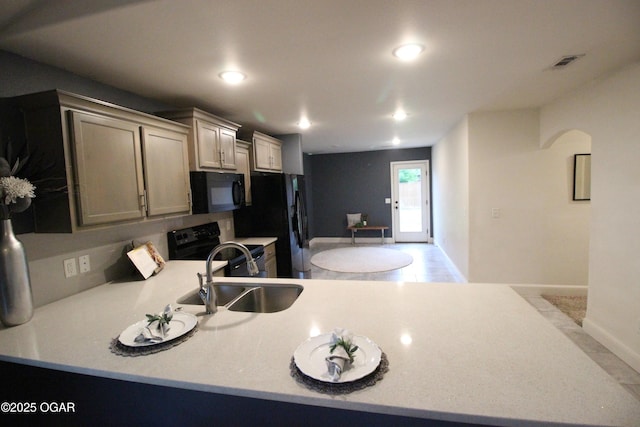 2102 Birdie Ln, Neosho, MO 64850 - kitchen featuring black appliances, light countertops, a peninsula, arched walkways, and recessed lighting