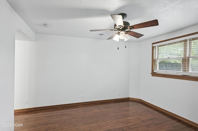 unfurnished room with wood finished floors, ceiling fan, baseboards, a smoke detector, and a textured ceiling