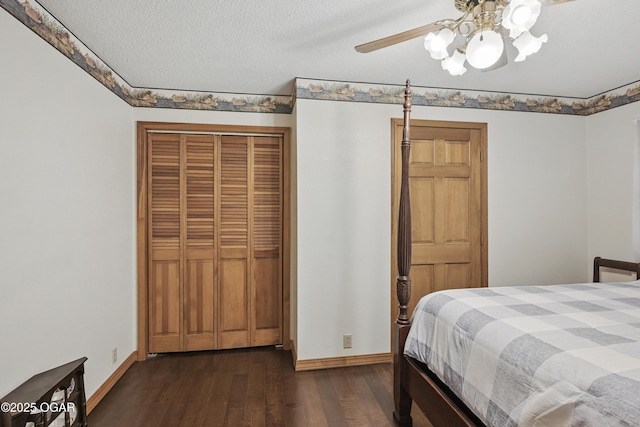 bedroom with baseboards, dark wood-type flooring, a closet, a ceiling fan, and a textured ceiling