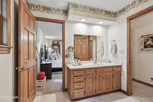 ensuite bathroom with vanity and baseboards