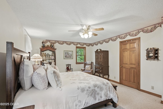 bedroom featuring light colored carpet, baseboards, a textured ceiling, and ceiling fan
