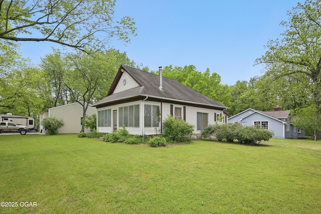 rear view of property with a yard and a shingled roof