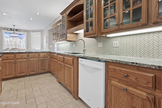 10208 Timberline Cir, Joplin, MO 64804 - kitchen featuring dishwasher, a sink, brown cabinets, decorative backsplash, and light stone countertops