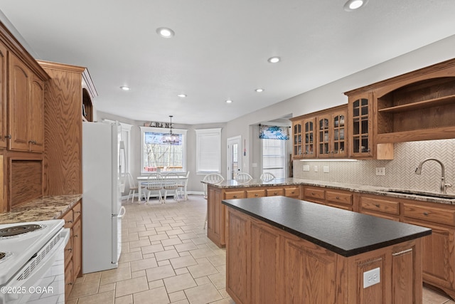 10208 Timberline Cir, Joplin, MO 64804 - kitchen featuring a sink, white appliances, brown cabinets, a peninsula, and recessed lighting