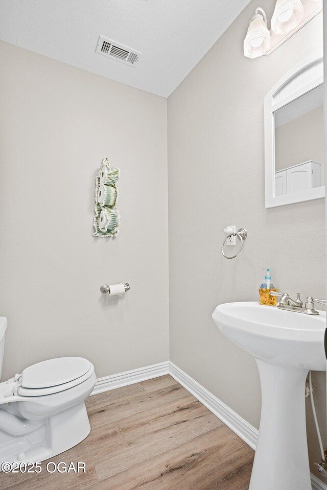 10208 Timberline Cir, Joplin, MO 64804 - bathroom with toilet, wood finished floors, baseboards, and a sink