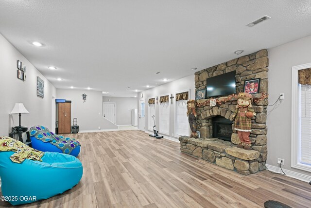 10208 Timberline Cir, Joplin, MO 64804 - living area featuring baseboards, wood finished floors, a stone fireplace, and recessed lighting