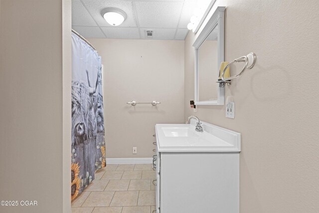 10208 Timberline Cir, Joplin, MO 64804 - full bathroom featuring a drop ceiling, vanity, tile patterned flooring, baseboards, and a shower with curtain