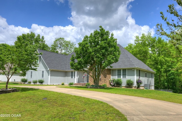10208 Timberline Cir, Joplin, MO 64804 - view of front of property with board and batten siding, curved driveway, a shingled roof, and a front yard