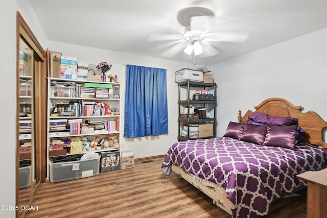 bedroom featuring wood finished floors, baseboards, and ceiling fan